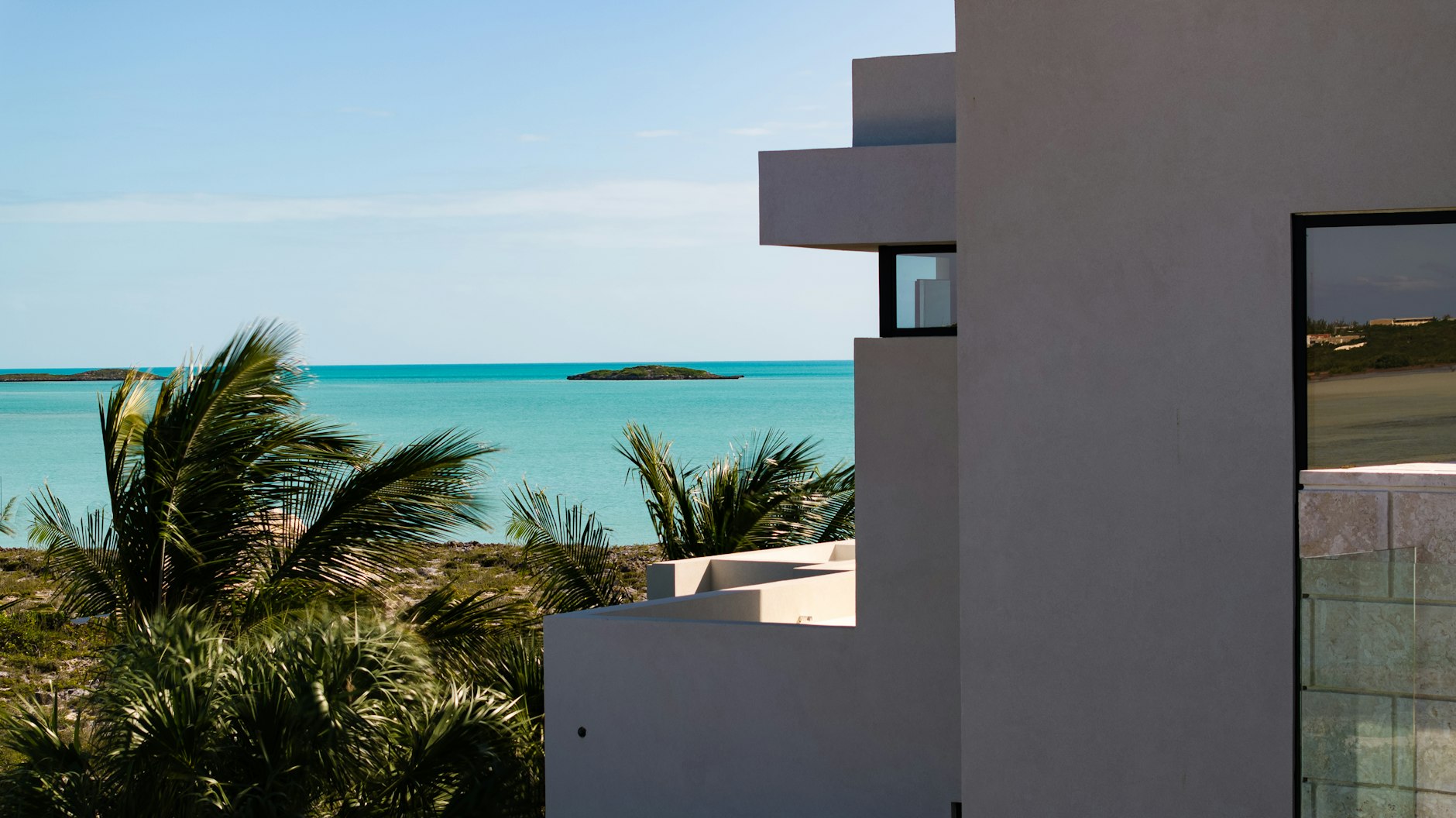 Maison moderne face à une mer turquoise
